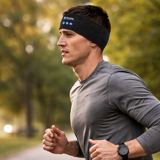 Man jogging outdoors wearing a black Bluetooth headband with built-in controls.