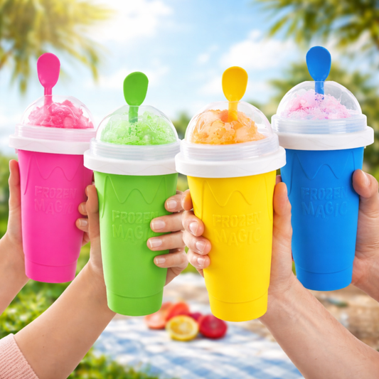 Four hands holding pink, green, yellow, and blue Frozen Magic slushy maker cups outdoors in a summer picnic setting.