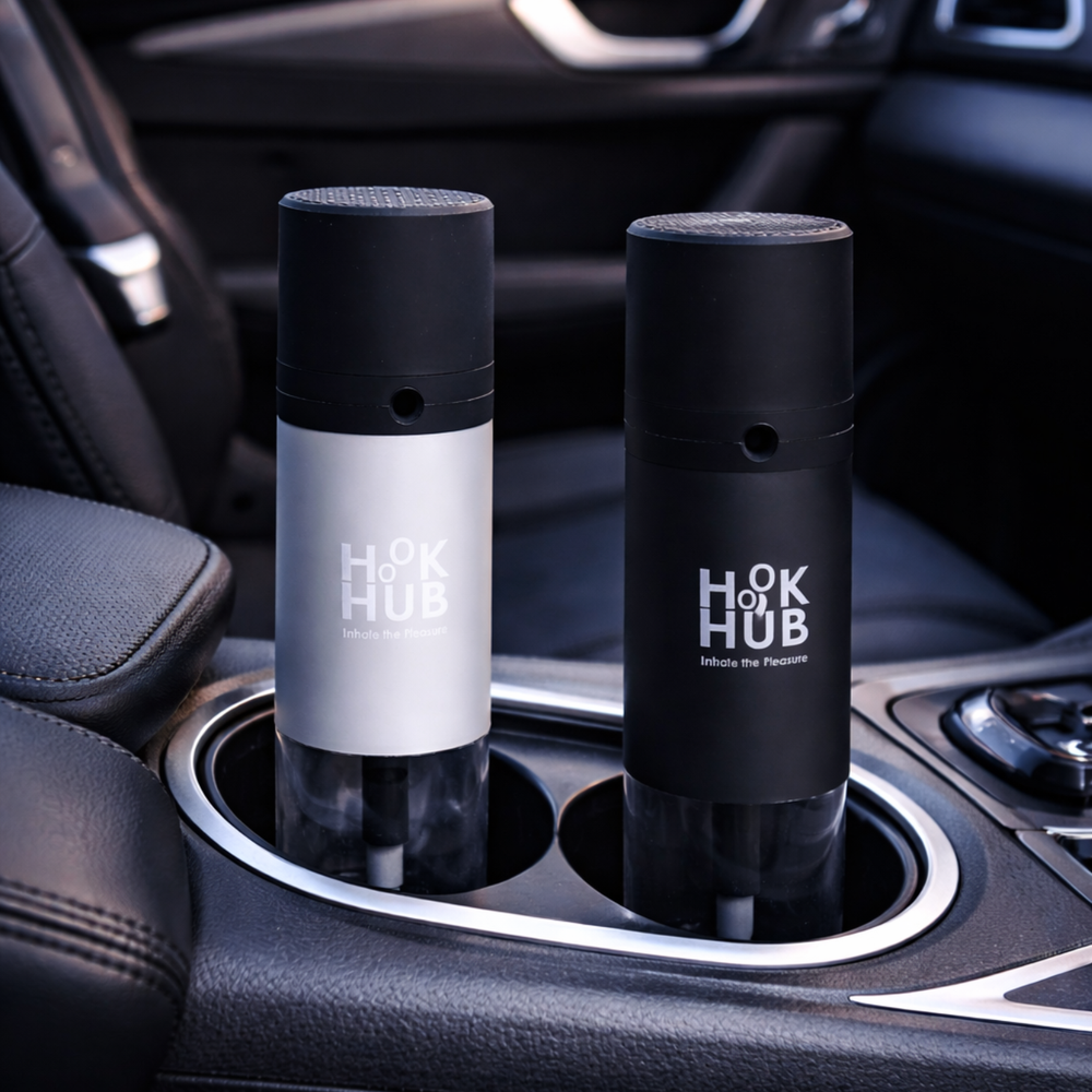 Hook Hub black and silver portable devices placed inside luxury car cup holders during sunset.
