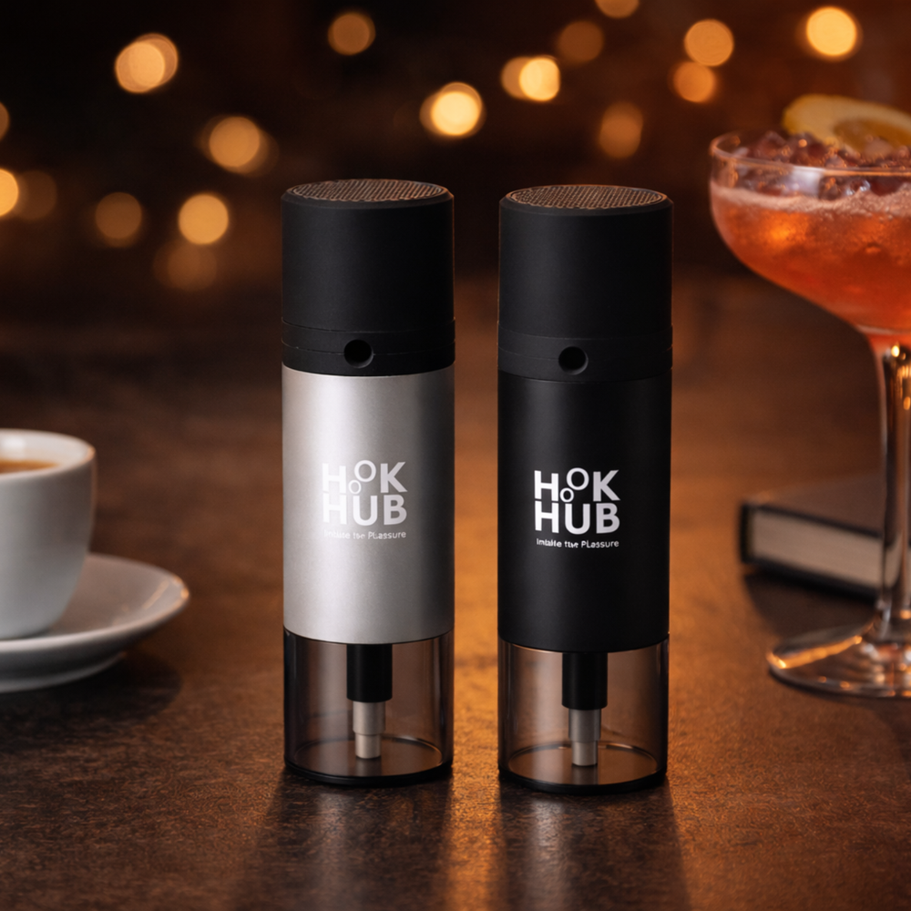 Hook Hub black and silver portable devices on a wooden lounge table with coffee and cocktails in warm evening lighting.