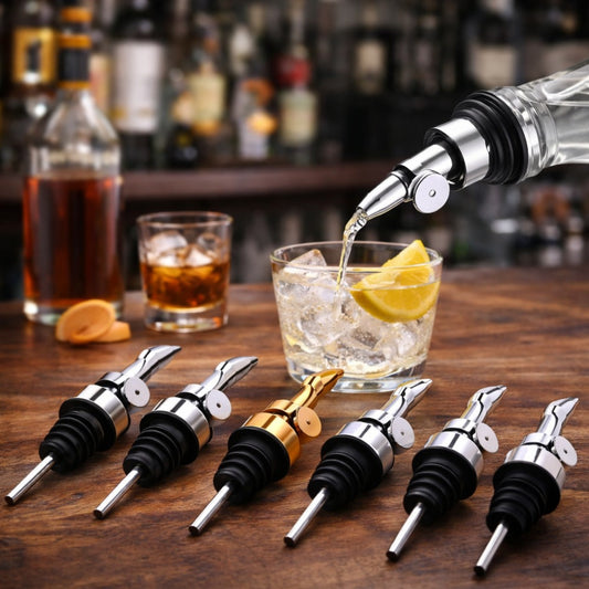Stainless steel pour spouts arranged on a wooden bar counter with one bottle pouring into a glass with ice and lemon in a bar setting.