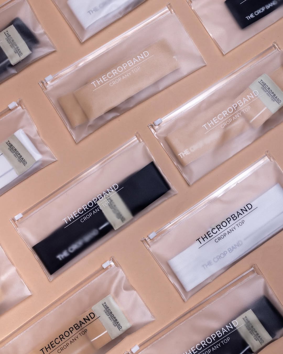 Multiple packets of 'The Crop Band' by THE CROP TOP in various sizes, primarily in beige and black colors, arranged against a beige background.