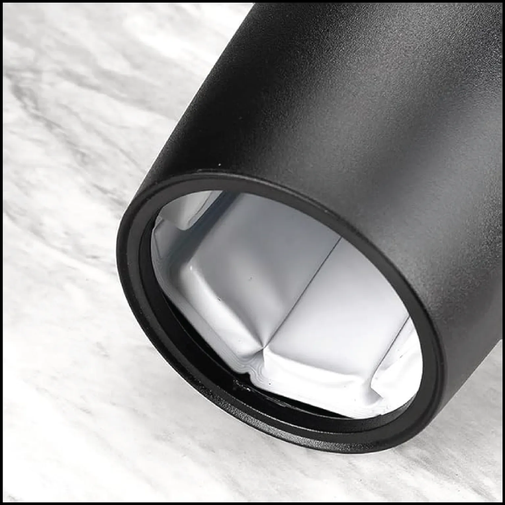 Top-angled close-up view of the inside of a black wine bottle chiller showing the cooling interior